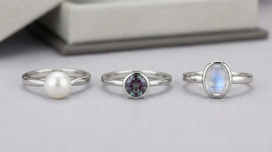 June birthstone ring designs: classic pearl in white gold, modern alexandrite solitaire, and protective bezel-set moonstone