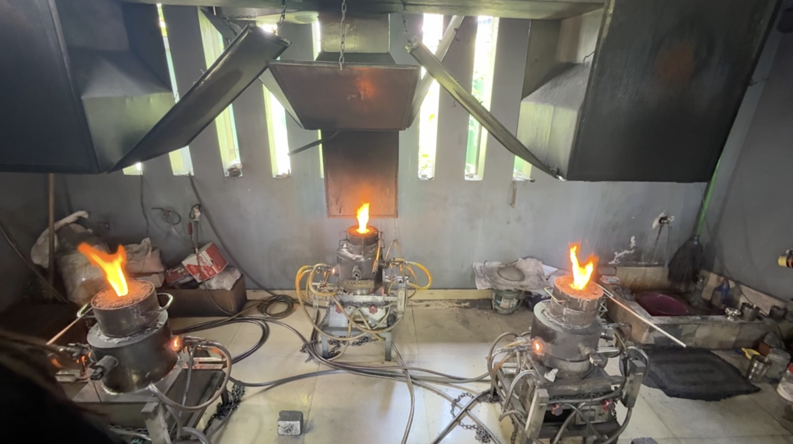 Corundum heat treatment furnaces burning with open orange flames in a Sri Lankan workshop, the process a pigeon blood ruby is still allowed to have been through
