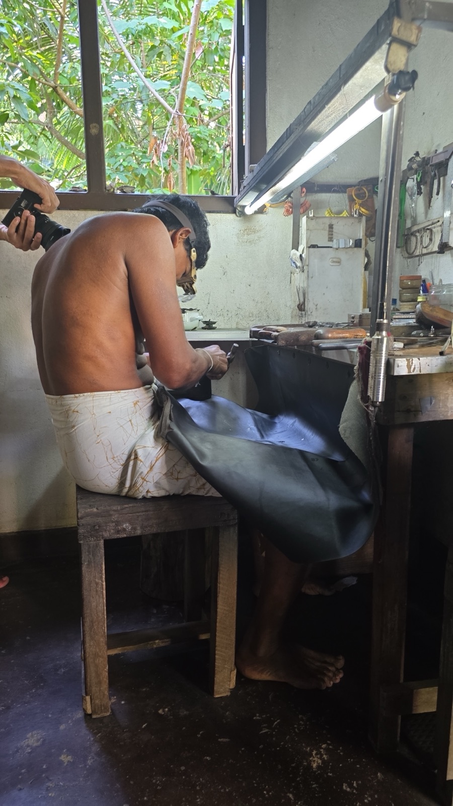 A Sri Lankan lapidary cutting a gemstone on a traditional wheel